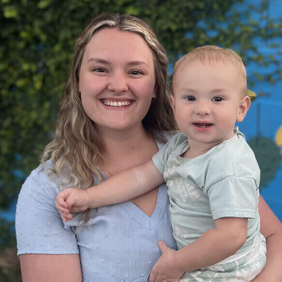 Isabella Horning, AFPA Certified Health Coach, holding a child.