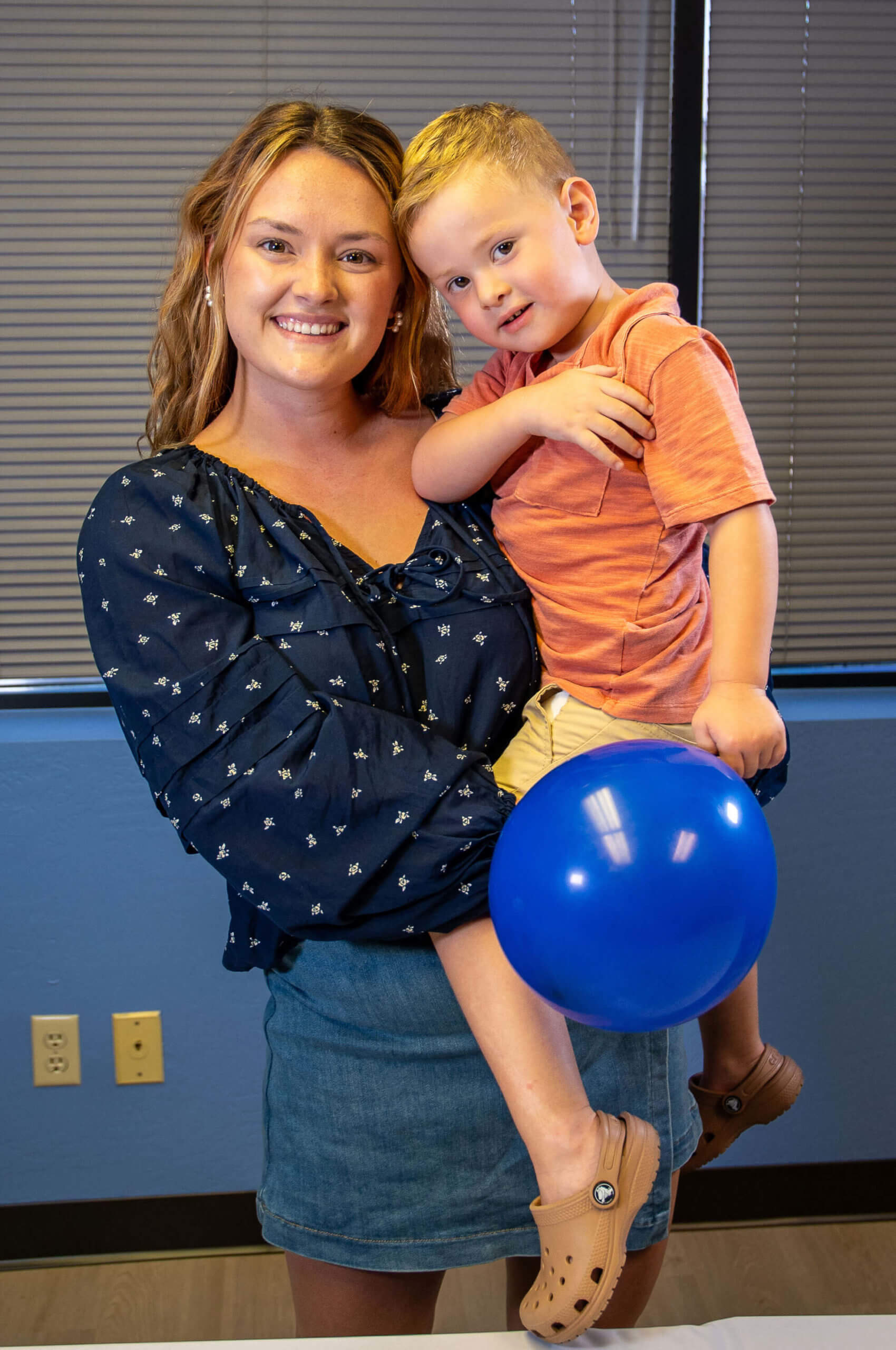 Isabella Horning, AFPA Certified Health Coach, holding a child.
