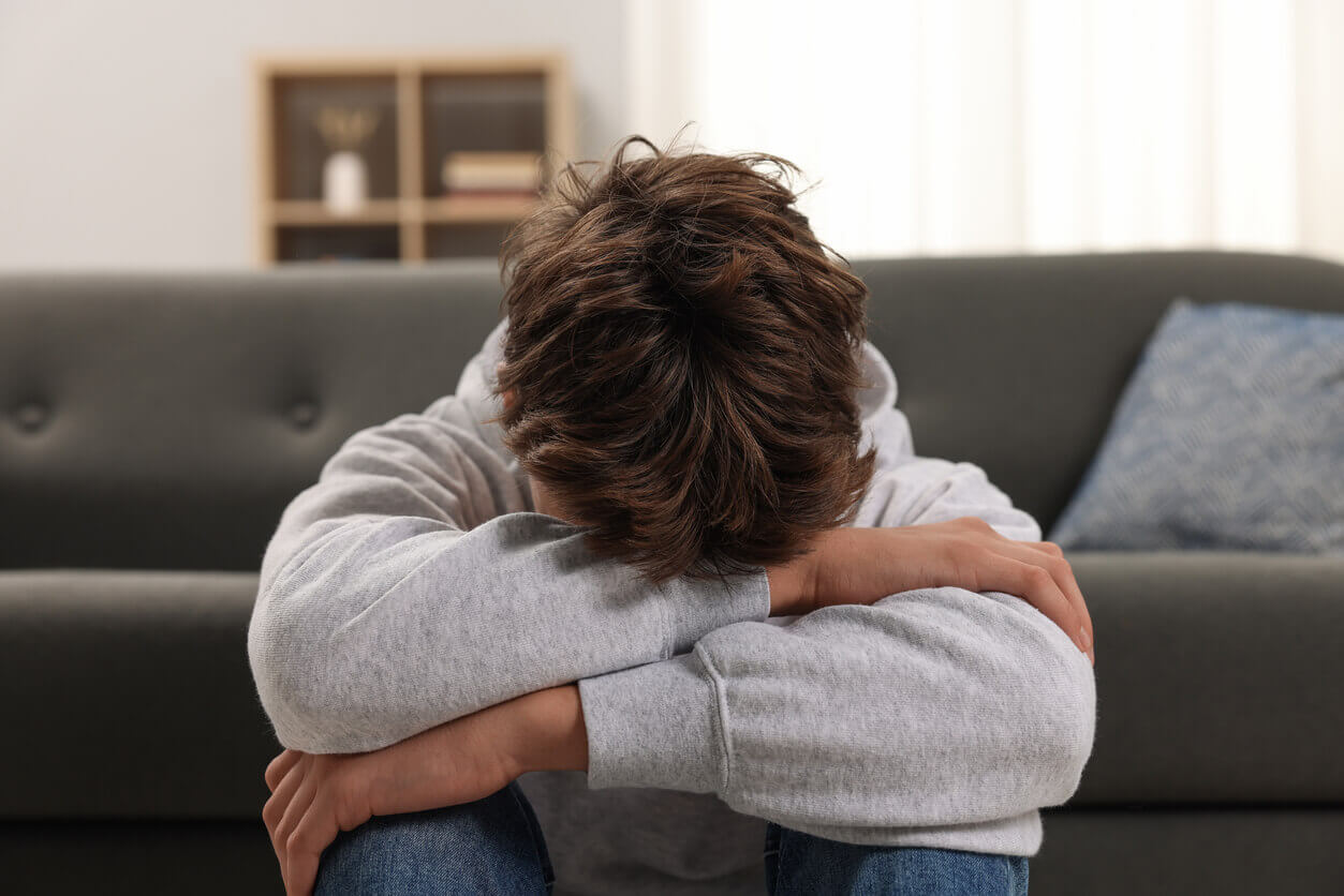 Sad teenage boy at home and suffering from depression.