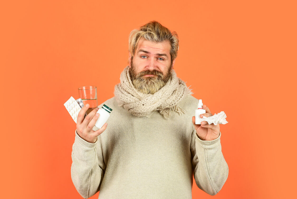 A man suffering from depression is holding several medications and Antidepressant Nasal Spray.